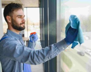 bearded-man-cleaning-office-window-with-spray-2026-01-08-22-30-54-utc-1024×681-1