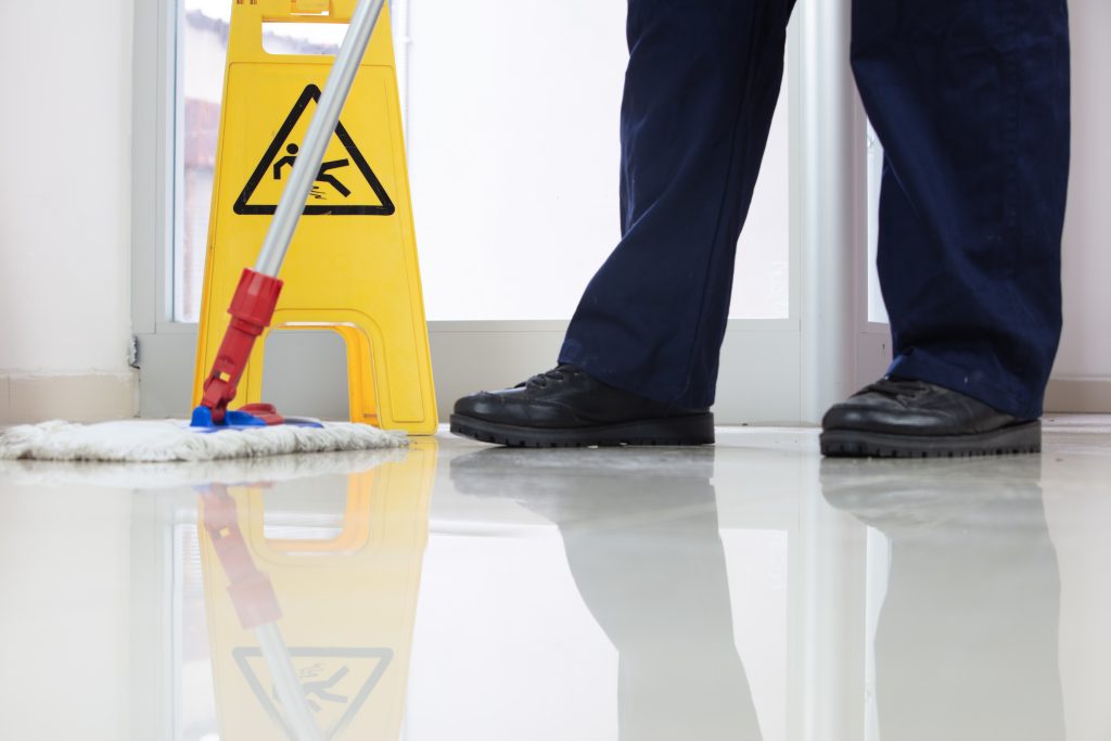 low-angle-closeup-person-cleaning-floor-with-mop-near-yellow-caution-wet-floor-sign-1024×683-1