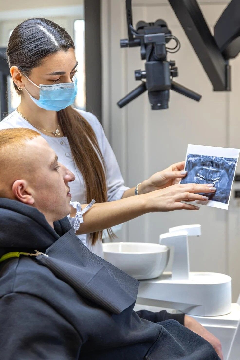 young-female-dentist-showing-patient-dental-xray-dentistry-concept_169016-669731